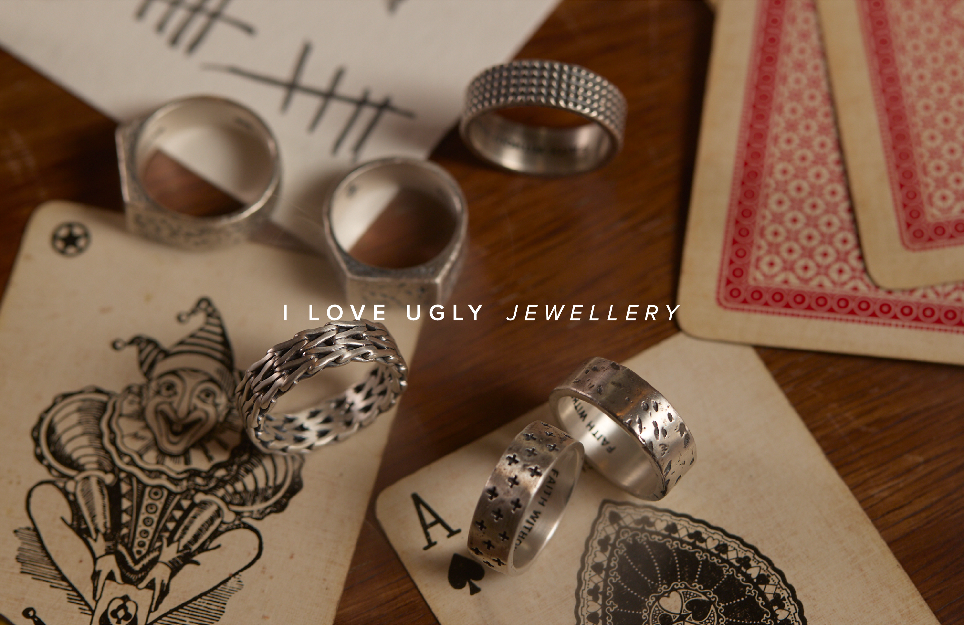 Rings on playing cards with text "I love ugly jewellery.